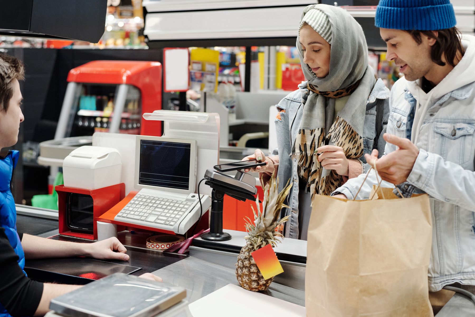 A customer completing a purchase at a grocery checkout