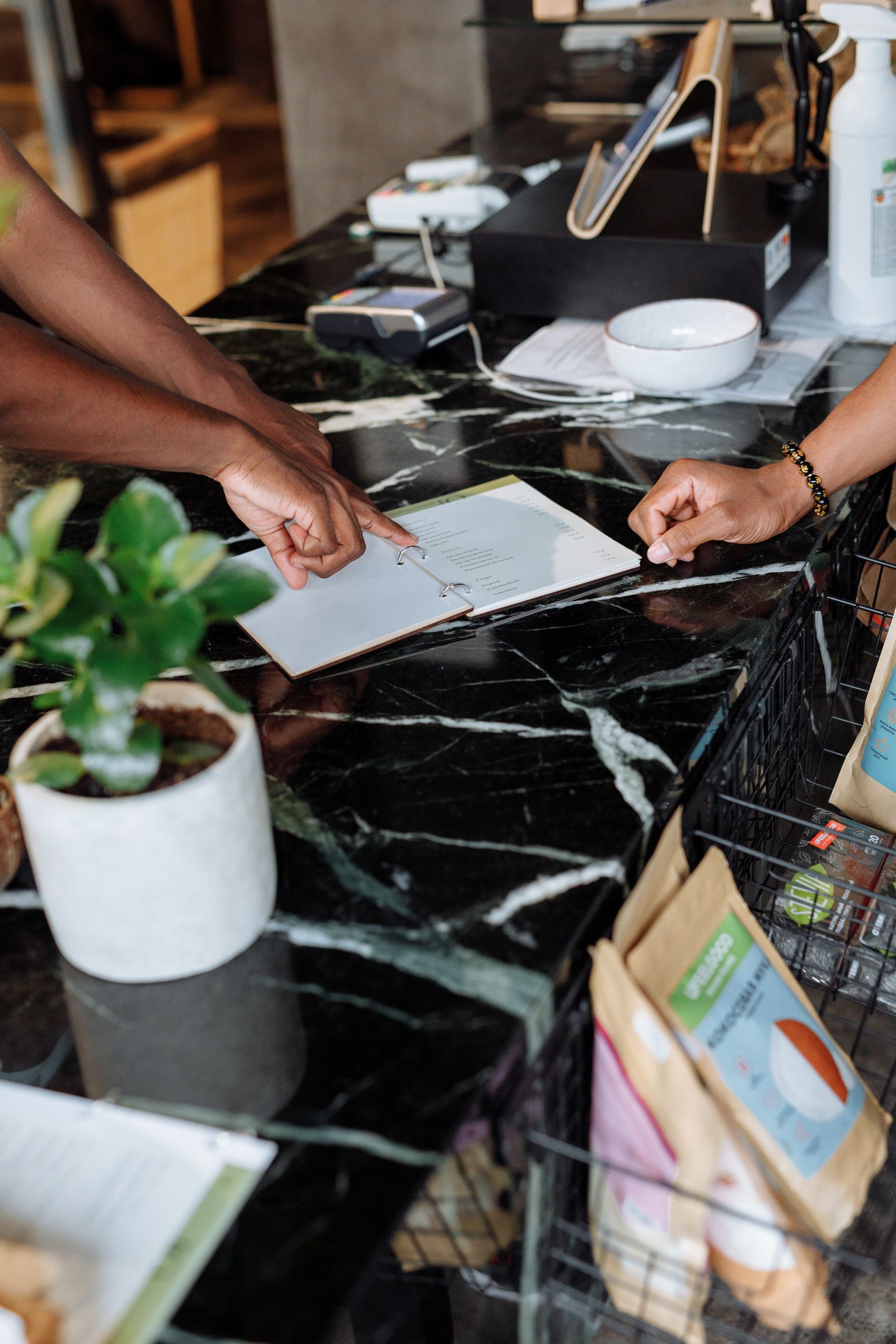 Two people reviewing a form together at a shop counter