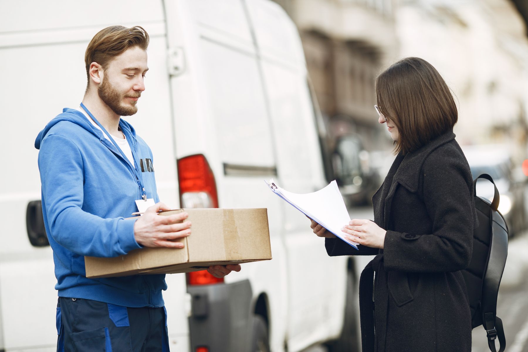 A delivery worker handing a parcel to a customer